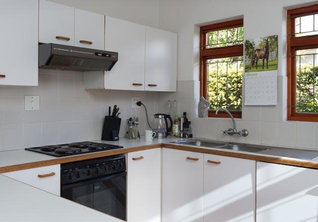 Kitchen with white cupboards and brown trim